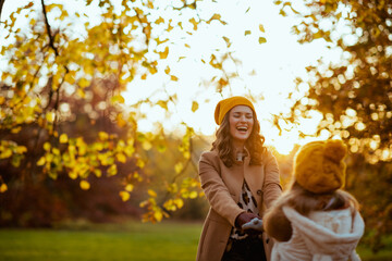 mother and child outside on city park in autumn having fun time