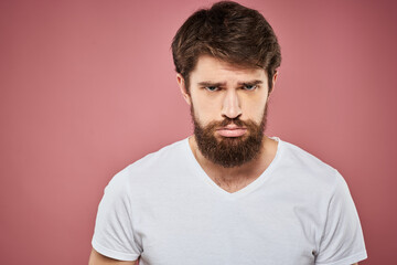 Man in white t-shirt emotions lifestyle facial expression cropped view pink background.