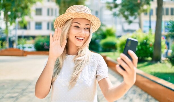 Young caucasian tourist girl doing video call using smartphone at city.
