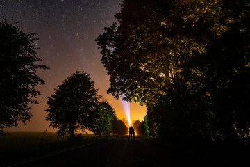 Overhead milky way with stars in clear summer night. Country side. Young couple standing with...