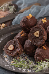 Dark chocolate truffles with hazelnuts on plate.