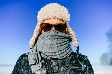 Fototapeta na wymiar Portrait of frozen man in sunglasses posing outdoors