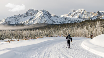 Cross country skiers in snow with beautiful mountain range