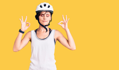 Beautiful young woman with short hair wearing bike helmet relax and smiling with eyes closed doing meditation gesture with fingers. yoga concept.