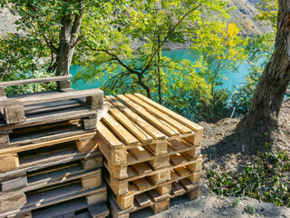 Wooden pallets stacked on the banks of a forest river