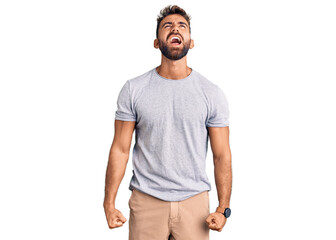 Young hispanic man wearing casual clothes angry and mad screaming frustrated and furious, shouting with anger. rage and aggressive concept.