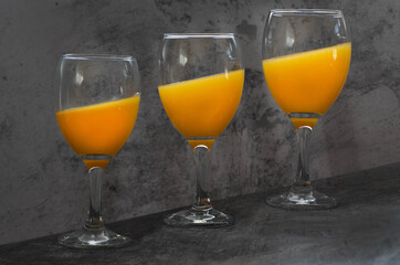 Cocktail glasses filled with colorful inclined drink isolated on grey background