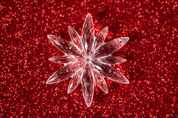 Christmas snowflake located in the center, red glitter background, selective focus,  free copy space