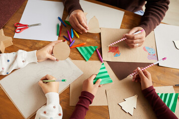 Above view close up of children drawing pictures during art and craft class in school, copy space