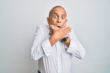 Handsome senior man wearing casual white shirt shocked covering mouth with hands for mistake. secret concept.