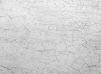 Old cracked white paint peeling off from wall texture background. Close-up detail of cracked paint.