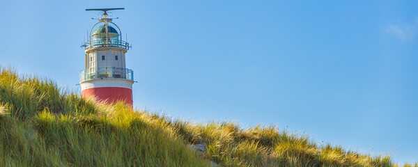 Banner close up view of Lighthouse at Waddenisland Texel, North Holland, Netherlands - obrazy, fototapety, plakaty