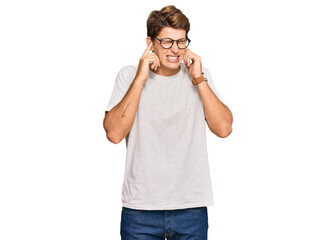 Fototapeta premium Handsome caucasian man wearing casual clothes and glasses covering ears with fingers with annoyed expression for the noise of loud music. deaf concept.