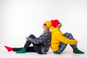 Fototapeta na wymiar Stylish couple of man and woman in colorful clothes posing over white background