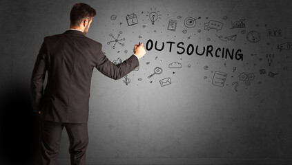 businessman drawing a creative idea sketch with OUTSOURCING inscription, business strategy concept