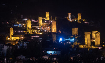 Fototapeta na wymiar Night panoramic view of a highland townlet Mestia with illuminated svan towers, Svaneti, Georgia.