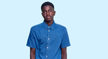 Fototapeta premium Young african american man wearing casual clothes looking sleepy and tired, exhausted for fatigue and hangover, lazy eyes in the morning.