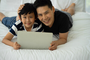 Asian father work from home businessman and son boy in house new normal social distancing. 