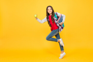 Fototapeta na wymiar Hurry up to take snack break. Energetic child run holding apple and books. School break. Nutrition education. Brain food. Healthy eating and snacking. Lunch time. Diet and dieting, copy space