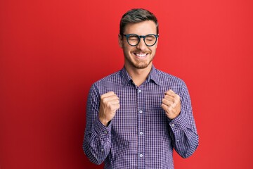 Handsome caucasian man wearing business shirt and glasses celebrating surprised and amazed for...