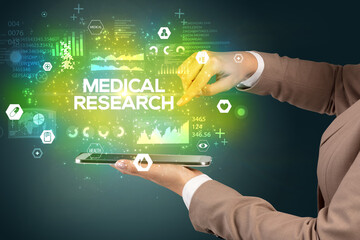 Close-up of a touchscreen with MEDICAL RESEARCH inscription, medical concept