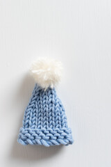 tiny blue pompom hat on white background 