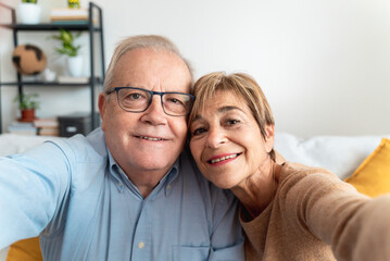 Senior couple taking a selfie at home - Elderly people technology concept