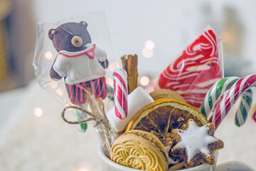 Christmas sweet food. Delicious Christmas sweets cookies, nuts, canes, marshmallows, candies in a grey mug close up