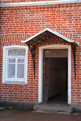 Fototapeta na wymiar Window and entrance on a red brick wall.
