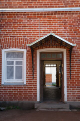 Window and entrance on a red brick wall.