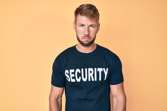 Young caucasian man wearing security t shirt depressed and worry for distress, crying angry and afraid. sad expression.