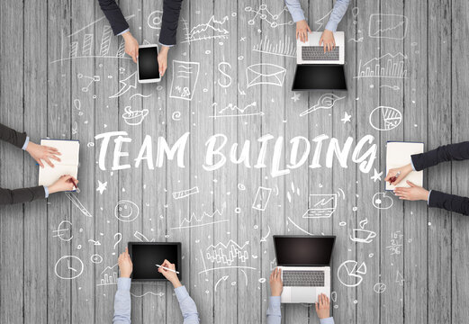 Group of business people working in office with TEAM BUILDING inscription, coworking concept