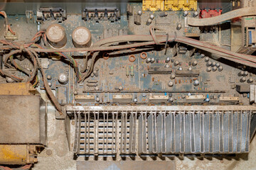 A dusty, dirty circuit board. Various components and wires covered with dust. Function and brand...