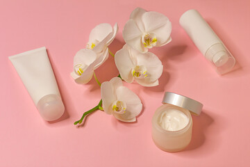 Obraz na płótnie Canvas Moisturizing cosmetics with orchid extract on pink background, beauty concept.