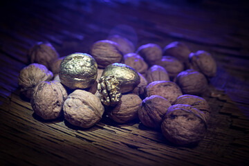 Still life with Walnut kernels and whole walnuts on rustic old wooden table. Creative table decoration.