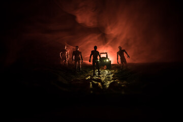 Fototapeta premium photo of a car stopped on the road lighting up a zombies. Silhouette terrible zombie night near the car. Miniature decoration.