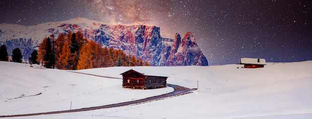amazing winter landscape at night with small cottage