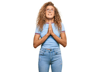 Beautiful caucasian teenager girl wearing casual clothes and glasses begging and praying with hands...