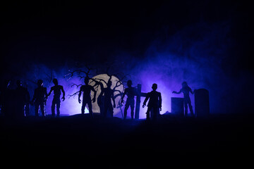 Scary view of zombies at cemetery dead tree, moon, church and spooky cloudy sky with fog, Horror...