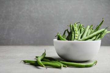 Fresh green beans on light grey table. Space for text