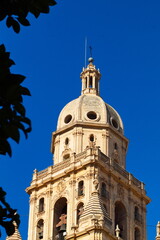 Fototapeta na wymiar Tower of the Murcia Cathedral emerges over the buildings