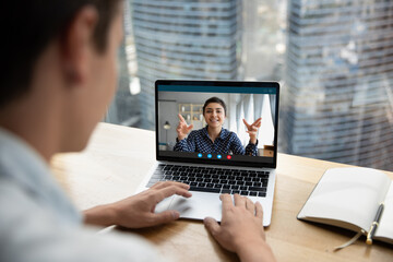Fototapeta na wymiar Focus on computer video call application screen happy friendly indian ethnicity businesswoman holding online meeting with colleague, consulting client remotely or mentoring employee distantly.