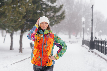 A young athletic girl poses on a frosty and snowy day. Fitness, running