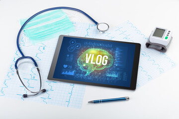 Tablet pc and medical tools with VLOG inscription, social distancing concept