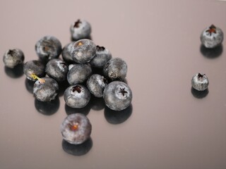Farm Fresh Blueberries scattered and spilled onto surface of reflective background