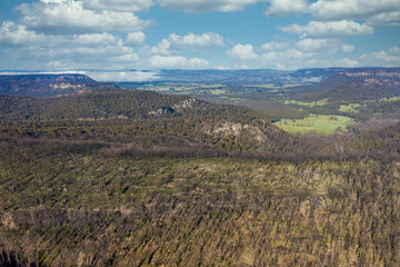 Aerial view of low clouds in a valley of forest regeneration after bushfires in regional Australia