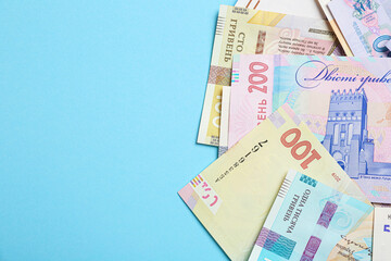 Ukrainian money on light blue background, flat lay. Space for text