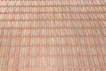 An old brown terracotta tiled roof on a house