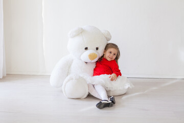 Beautiful little girl holding a white teddy bear toy
