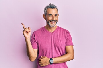 Middle age grey-haired man wearing casual clothes smiling happy pointing with hand and finger to...